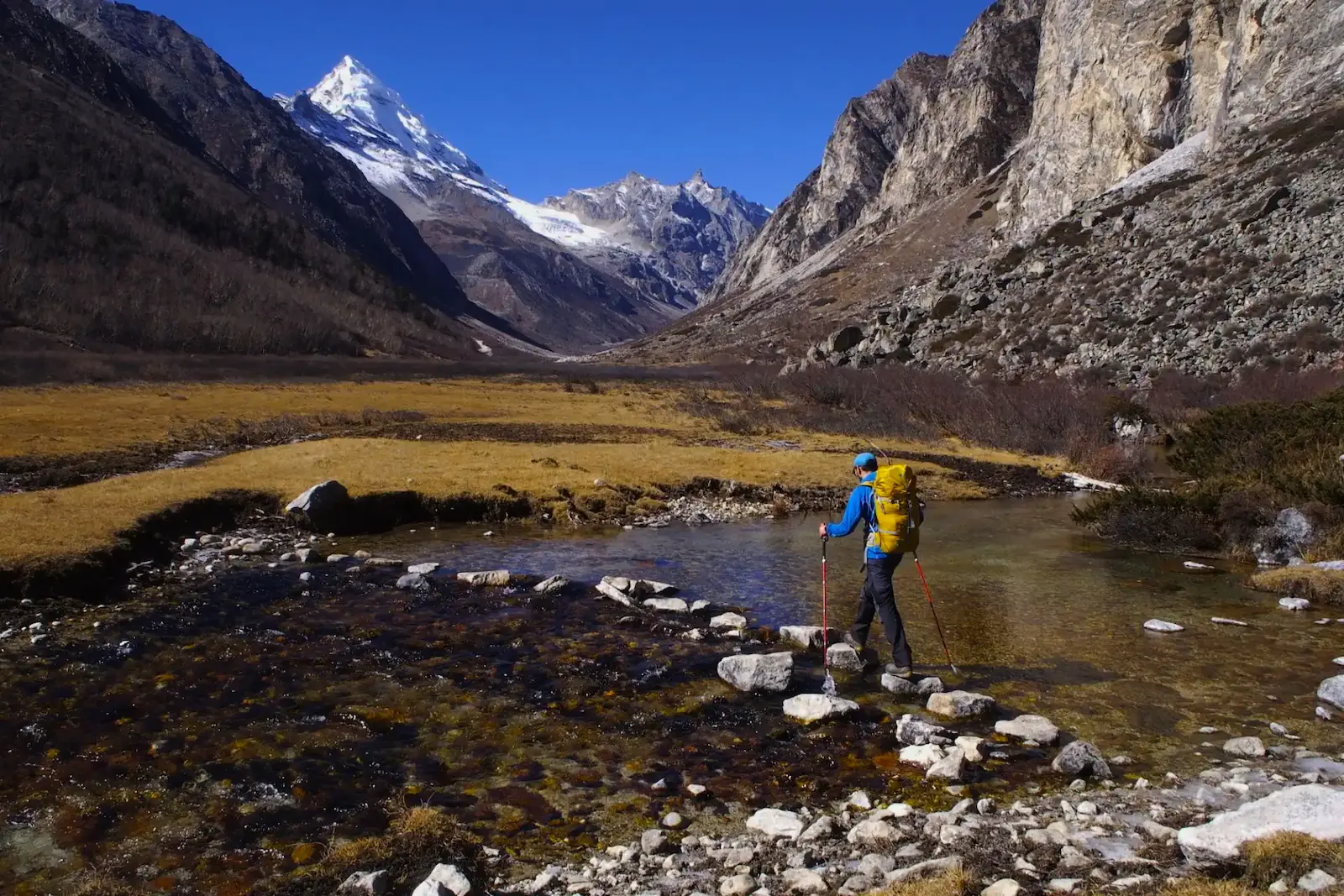 A solo trekker walking on a remote mountain trail during an off the beaten path trek in Nepal.