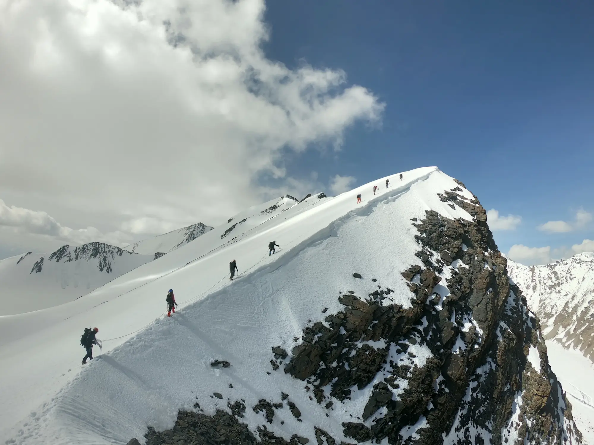 Climbers ascending a steep alpine route in Nepal using lightweight alpine style techniques