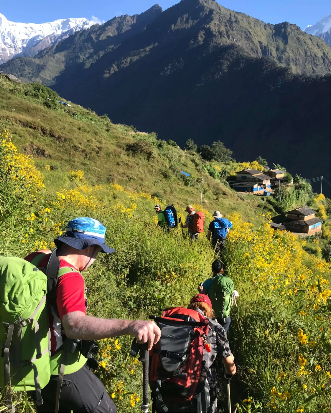 Trekkers walking along a scenic trail in the Nepal Himalayas surrounded by mountains and valleys